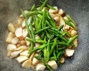 待杏鲍菇熟，转大火倒入芦笋。