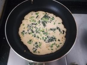 热锅刷油。倒入一勺面糊。