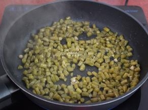 热锅，倒入酸豆角，小火煸炒，切记，不要放油，叫白锅炒，这样可以去酸味水，炒出的酸豆角才好吃；
