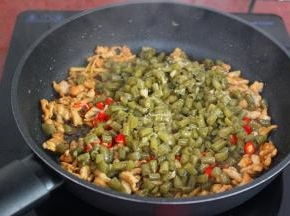 把煸炒好的豆角也加入，翻炒；