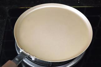 开小火，将学厨的9寸不沾千层锅放上炉上，轻晃几下热锅