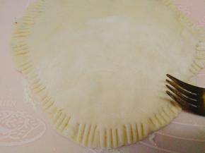 把另外一个面皮盖上，边缘捏合，也可以用叉子压花边（馅子用现拌的方式更能保证鲜度，避免了因为提前加入盐而造成韭菜出水的情况，这样烙好的饼才多汁。再打入一个生鸡蛋烙好后的馅子不那么散，而且更香）