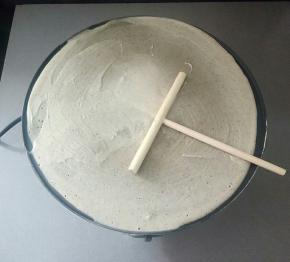 把面糊倒入，用摊饼棍圆周运动使面和迅速蔓延开来，小火煎制凝固