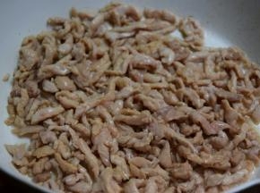 将肉丝倒入锅翻炒至变色
