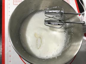 中速打至蛋白细腻的时候，再次加入三分之一份糖，并上火130度，下火110度预热烤箱。