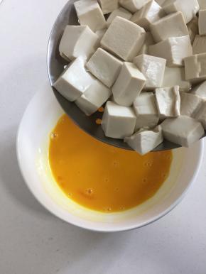 把处理好的嫩豆腐放入蛋液中。