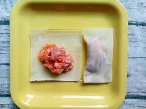 将搅拌好的胡萝卜肉末包在馄饨皮中