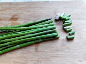 首先处理芦笋，将根部切掉，如图。冷水冲洗干净。