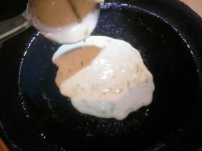 刷少量油，舀一勺面糊倒在饼铛中间，用勺背摊成薄饼