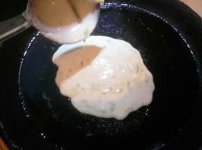 刷少量油，舀一勺面糊倒在饼铛中间，用勺背摊成薄饼