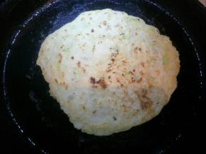 适量转一下饼铛，表面凝固后刷少量油，翻面