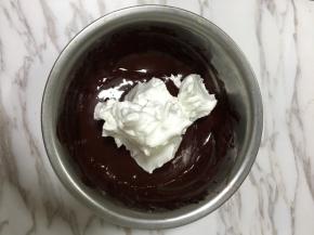 5.先将三分之一打发好的蛋白加入蛋黄糊用刮刀轻轻翻拌均匀，注意手法，不要打圈，可以用十字翻拌法，混合好后全部倒入蛋白中