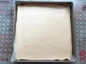 蛋糕糊倒入铺了油纸的烤盘里，轻震2下烤盘，去掉蛋糕糊里的气泡