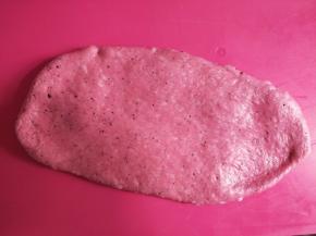 发酵好的面团用擀面杖排气后，分成三份，取一份面团擀成舌状。