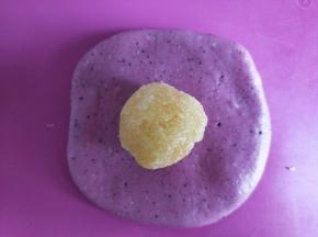 取一个面团擀成圆形，包入一个椰蓉馅。