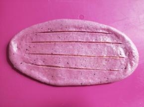 擀开呈舌状，用锋利的刀在中间划四刀，头尾不要切断。