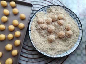 在面团上抹少量的水沾稳芝麻