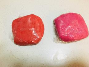 油酥部分，油酥材料混合，用刮刀搅拌成团，这部分加入红丝绒精华，颜色随自己喜好调，这两团油酥，一个加了红丝绒精华，一个用了粉色的色粉，揉成团后包裹保鲜膜冷藏30分