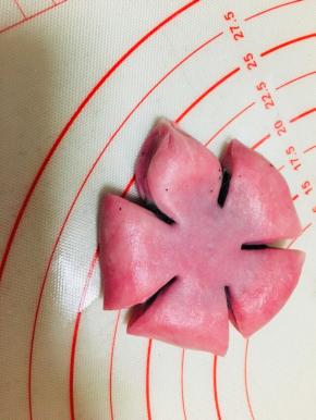 将包裹好的面团按扁，平均分成5份，用剪刀剪开，中间不要剪断，捏紧扇形顶端部分，捏出花瓣。