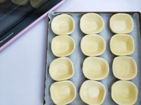 把蛋挞皮放入铺好油纸的烤盘上。