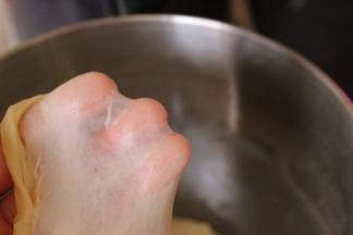 把除黄油、杏仁片、香芋紫薯泥以外的其他材料放入面包机中揉成光滑的面团，加入黄油继续揉至完全阶段，用手可以拉出大片薄膜