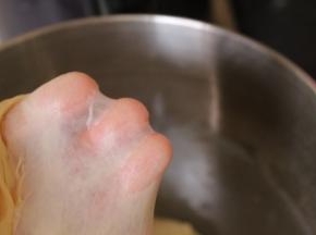 把除黄油、杏仁片、香芋紫薯泥以外的其他材料放入面包机中揉成光滑的面团，加入黄油继续揉至完全阶段，用手可以拉出大片薄膜