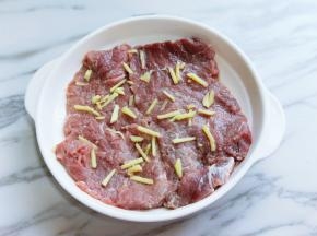 将牛排放入器具中，加入切好的姜丝。(牛排冷水泡30分钟，中途可以换清水)