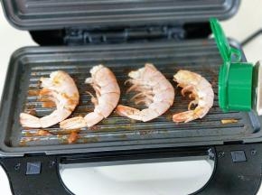 再把阿根廷红虾尾摆放在烤盘上，撒上黑胡椒粉，盖上盖子煎至2分钟即可出锅。