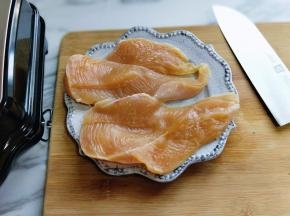 首先将鸡胸肉洗干净，之后把一块鸡胸肉一切二。