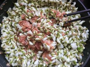 放入槐花，一个方向搅拌均匀。