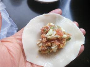 饺子皮边缘蘸上清水，放适量的肉馅。