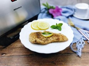 将鸡肉夹出，装盘，摆上两片柠檬装饰。