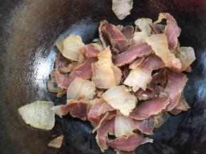 再起锅，倒入腊肉煎炒出油