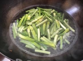 另起锅烧开水，放入蒜苔煮断生