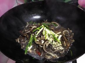 转大火，倒入肚丝、剩下的一半葱段、蒜碎迅速翻匀