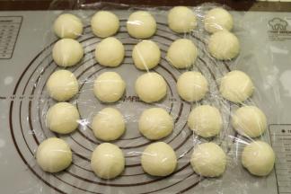 将面团轻压排气后平均分成25小份（一个大约味道30克），盖上保鲜膜醒发15分钟