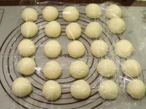 将面团轻压排气后平均分成25小份（一个大约味道30克），盖上保鲜膜醒发15分钟