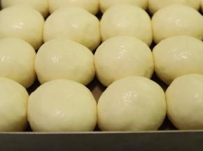 烤箱预热170度，将发酵好的面团取出，表面喷少许水