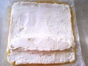 冰箱取出淡奶油，用刮棒均匀的涂抹在蛋糕表面，靠近自己的这面多一点