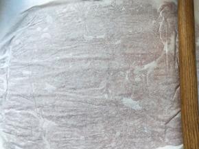 撕一块油纸，把肉平铺在油纸上，再盖上一张油纸，用擀面杖来回的擀，擀干擀均匀。