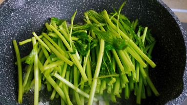 先将梗的部分入锅翻炒