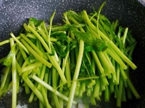 先将梗的部分入锅翻炒