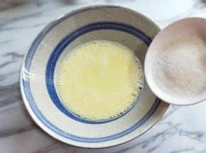 用手动打蛋器打至均匀，再加入白砂糖，继续用手动打蛋器，打至均匀使汤融化。