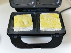 待黄油融化时，把做好的吐司面包片放入烤盘上。