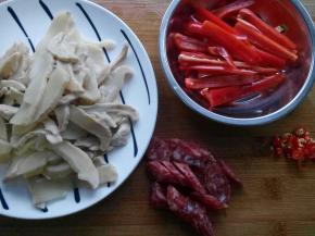 浸泡两天的笋干，用高压锅压十分钟后切片。腊肠切片。红椒切长段，姜、蒜少许。