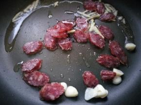 放入腊肠煸炒出油。