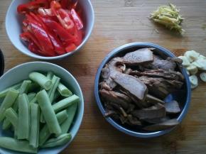 四季豆用手摘断，招财切片，辣椒切小段，蒜切片，姜切丝。