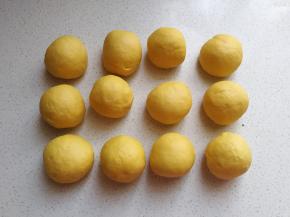 把发酵好的面团取出挤压排气，然后分成均匀的12个小剂子滚圆盖保鲜膜静置10~15分钟