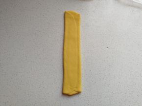 再用擀面杖把面皮擀长，注意不要擀太宽，宽度比模具宽度稍微短一点即可