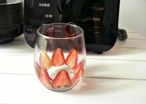 取一颗新鲜草莓切薄片，贴在杯壁上